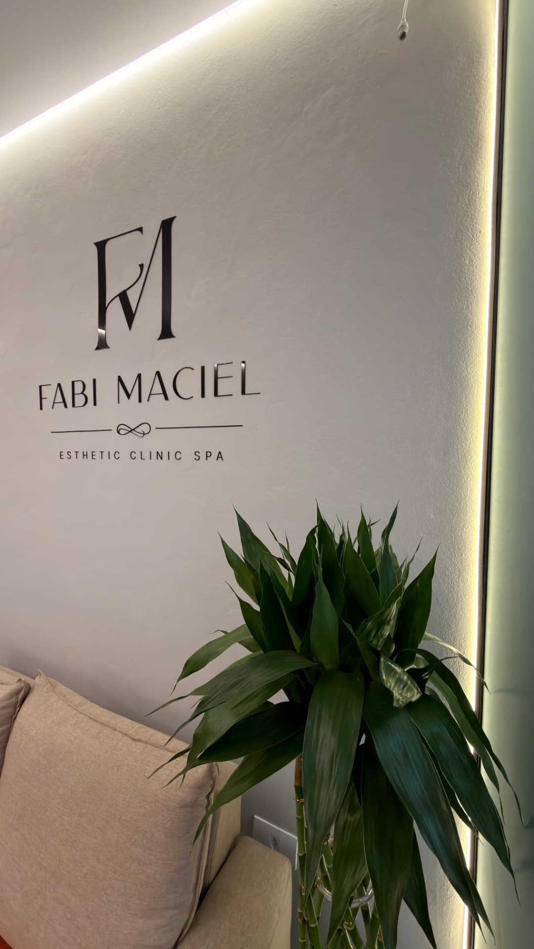 Recepção da Fabi Maciel Esthetic Clinic Spa com logo iluminado